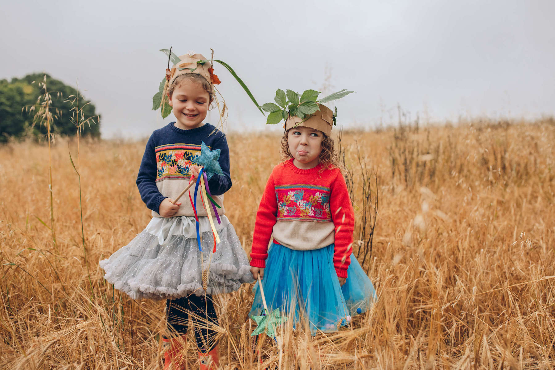 Two girls stood in a field wearing The Faraway Gang jumpers.