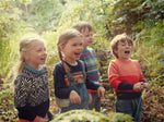 A gang of young children in the woods wearing The Faraway Gang children's jumpers.