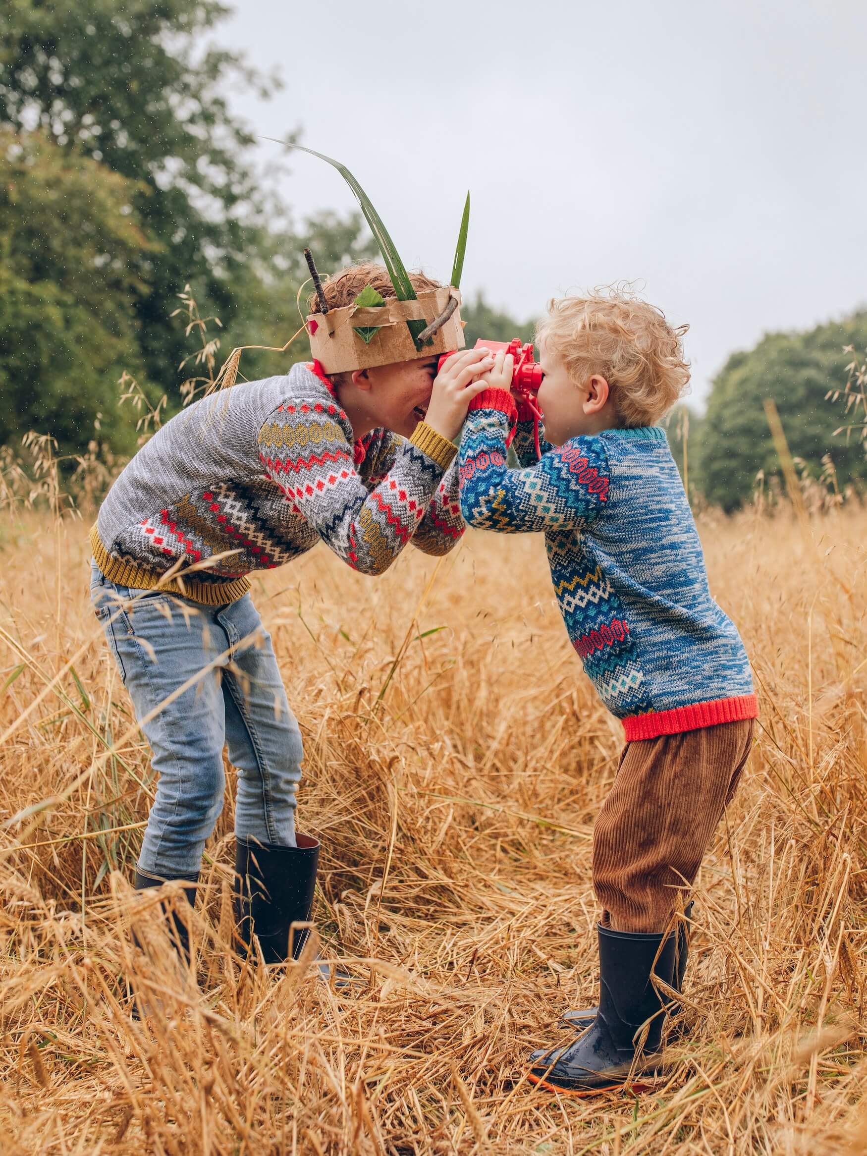 two brothers standing in a field wearing 'Daydreamer' Knitted Jumpers from The Faraway Gang being silly.