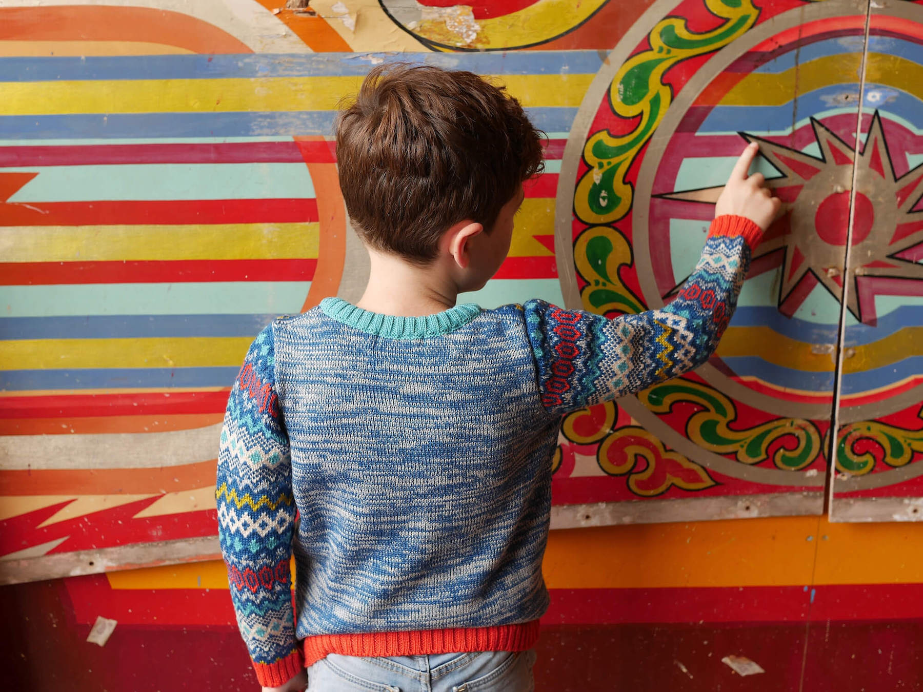 Boy wearing The Daydreamer Knitted Jumper with his back to us.