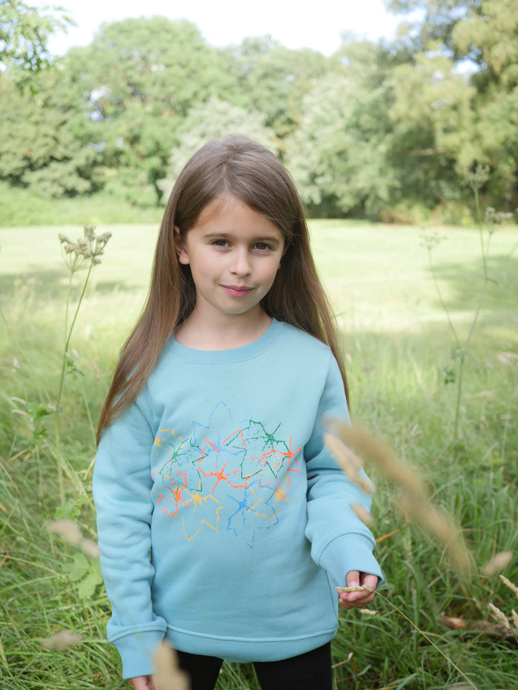 Girl wearing The 'Rambler' Children's Printed Sweatshirt stood in a field.