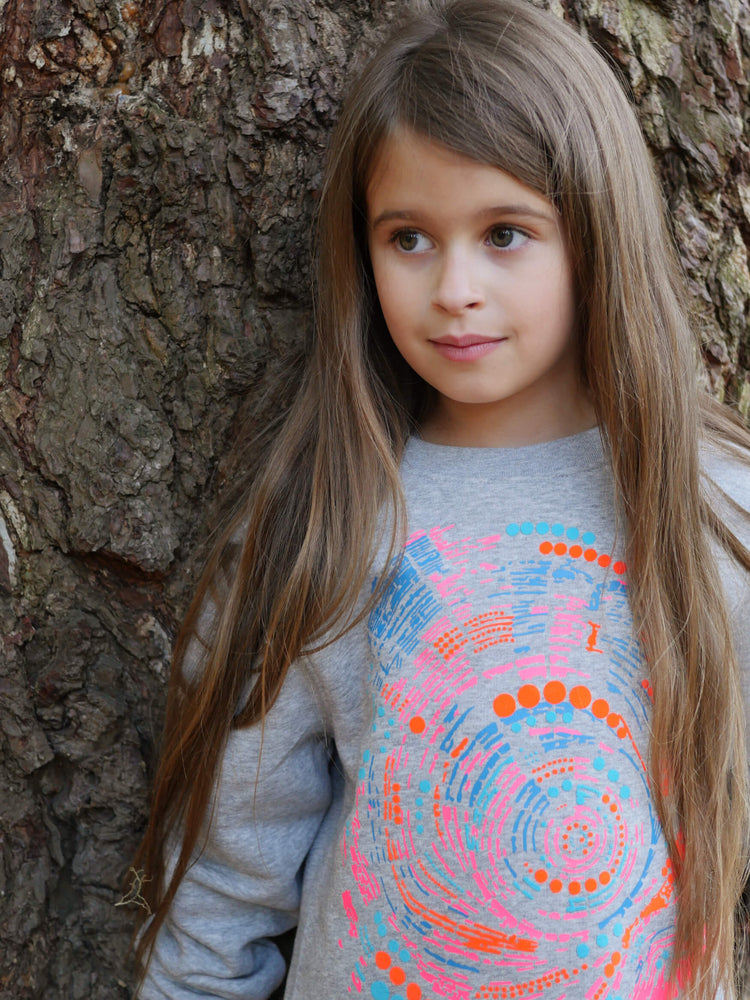 Girl leaning against a tree wearing The 'Climber' Children's Printed Sweatshirt.