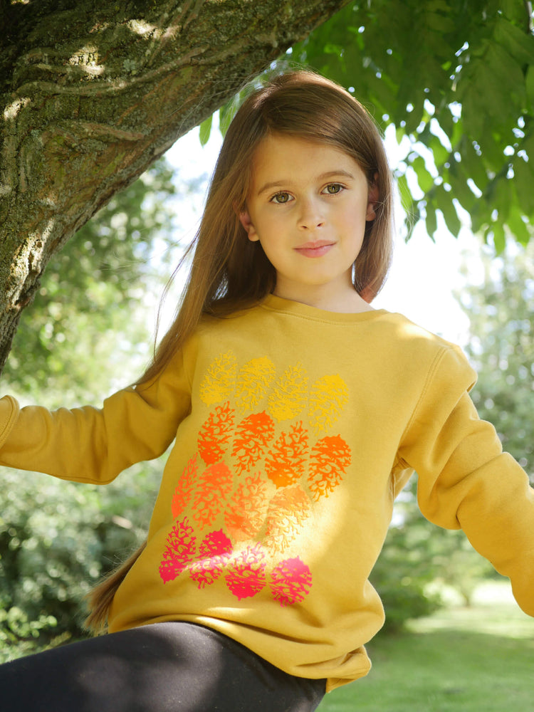 Girl sitting in a tree wearing The 'Forager' Printed Sweatshirt.
