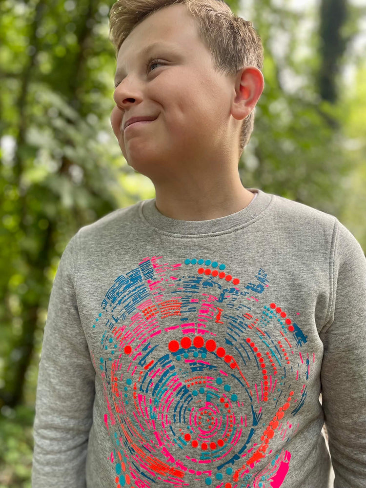 Boy wearing The 'Climber' Children's Printed Sweatshirt looking up and smiling.