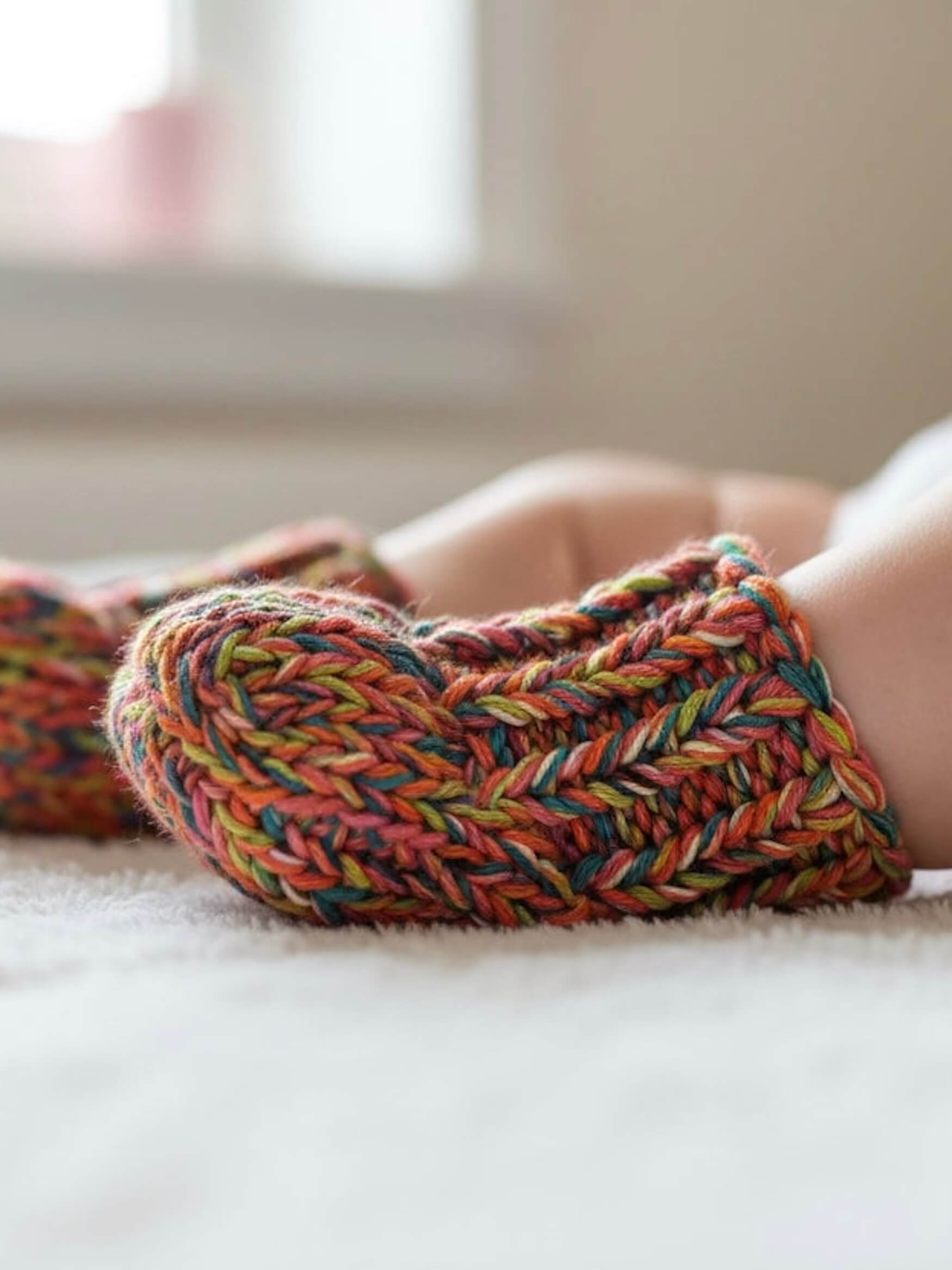Colorful knitted socks on a person's feet with a blurred background
