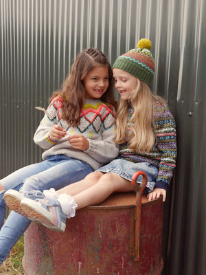 Two young girls chatting wearing The Faraway Gang knitwear.