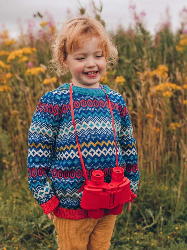
            
                Load image into Gallery viewer, A little girl standing in a field with The Faraway Gang&amp;#39;s &amp;#39;Daydreamer&amp;#39; Knitted Jumper smiling with a camera round her neck.
            
        