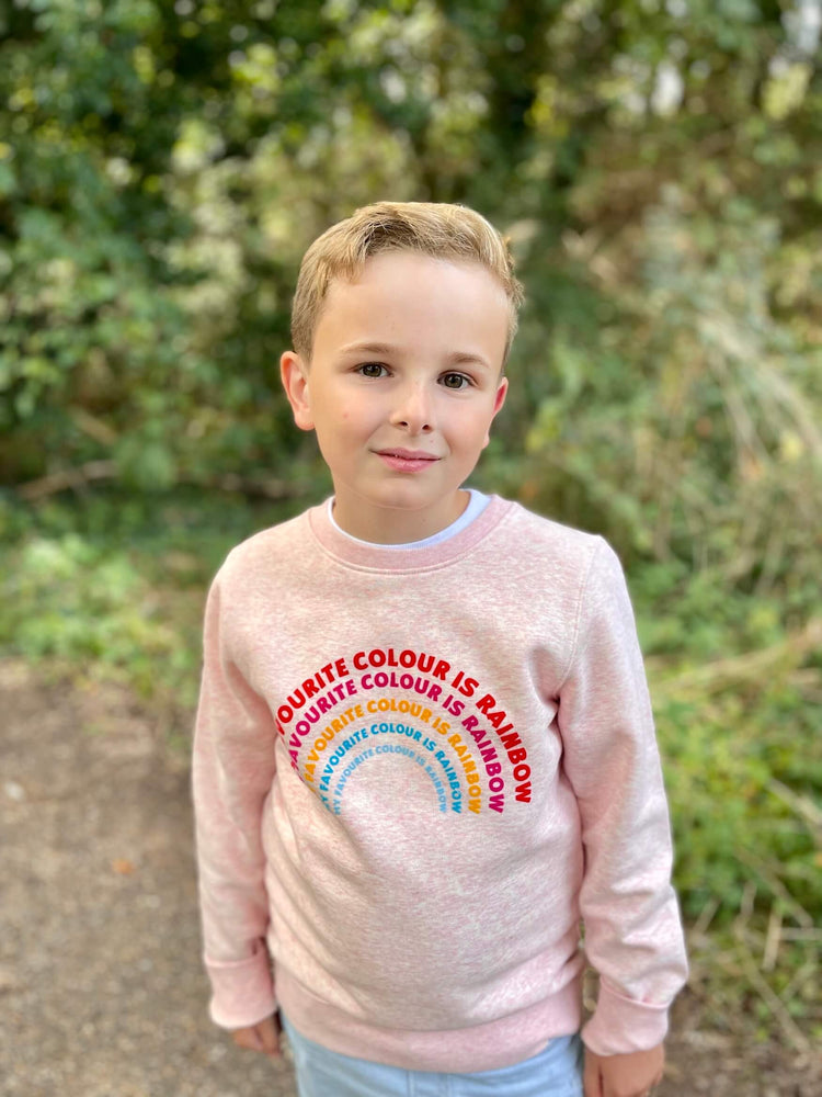 a pink 'Rainbow' Sweatshirt by The Faraway Gang with a rainbow on it.