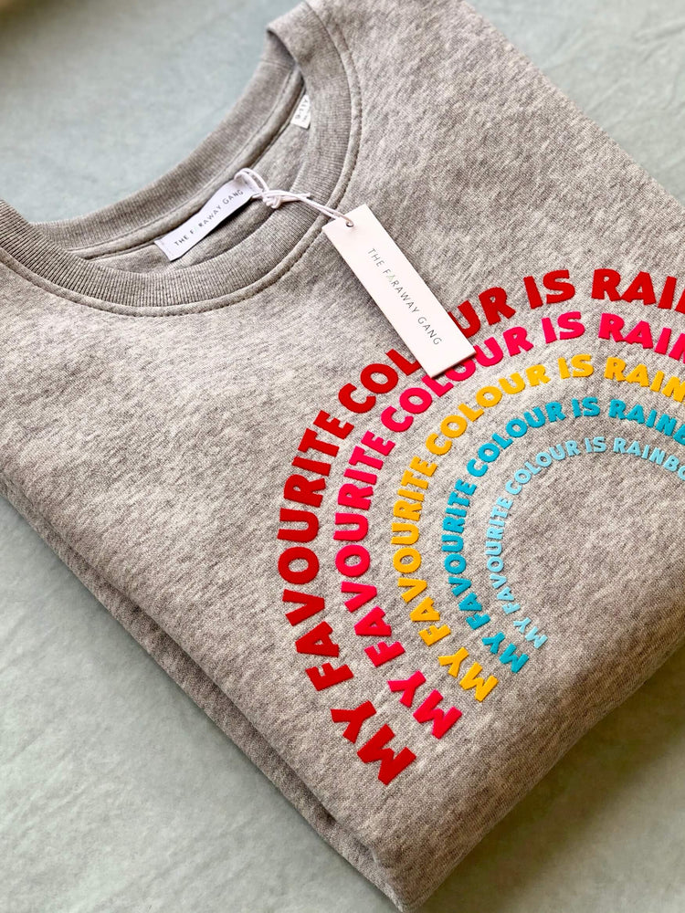 a 'Rainbow' Sweatshirt by The Faraway Gang with a rainbow on it .