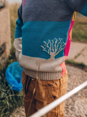 A close up of a tree detail knitted into the little boy jumper by The Faraway Gang.