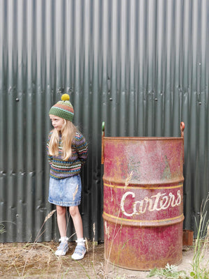 Young child stood next to an oil drum wearing The Faraway Gang unisex clothes.